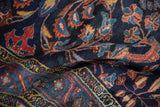 Plush texture of a vintage Persian carpet with scrolling vines in red and blush tones.