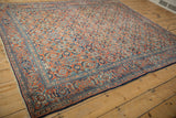 Vintage Tabriz carpet's navy border and brick red field with Herati motifs.