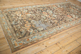 Angled view of a distressed Malayer runner showing worn foundation amid tangerine and blue floral bouquets.