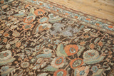 Textured wear exposing the foundation on a distressed Malayer rug with floral bouquets.