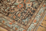 Corner view of a distressed Malayer rug highlighting the worn texture and detailed floral motifs.
