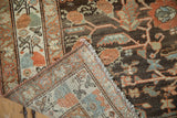 Folded corner of a distressed Malayer runner showing its hand-knotted foundation and machine-bound side.