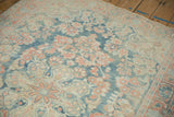 Angled view of the abrashed sky blue field and floral motifs on a distressed Mahal rug.