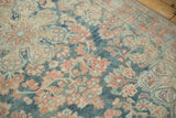 Angled close-up of the distressed Mahal rug's low pile and floral pattern.