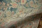 A folded view of the distressed Mahal rug, showing the texture of its low, hand-knotted pile.