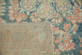 A folded corner of a vintage Mahal rug showing the hand-knotted weave and colorful floral pile.