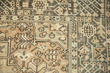 Geometric borders and low, even pile on the corner of a vintage distressed Persian Karaja rug.
