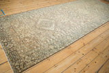 Angled lengthwise view of a distressed Karaja runner, showing its column of medallions in neutral tones.