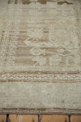 Muted pale coffee brown Oushak rug pile with distressed Samovar floral field and vine border.