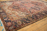 Vintage Heriz rug's navy main border, seeded vine, floral motifs, and fringe.