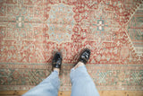 Low, worn pile of a vintage Karaja runner with geometric medallions in brick red and seafoam green.