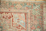 Low-pile corner of a vintage Karaja rug with a jade green and red geometric border.