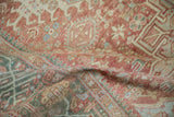 Draped view of the distressed Karaja rug's low pile in brick red and seafoam green.