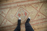 Worn texture on the serrated diamond medallion of a vintage Persian Serab runner.