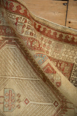 A rolled vintage Serab runner showing its low, worn pile and reciprocating pawn motif border.