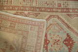 Folded corner of a distressed Serab runner detailing the hand-knotted pile and secured side selvage.
