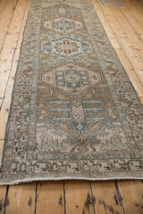 Distressed texture of the vintage runner, highlighting geometric motifs in muted blues and browns.