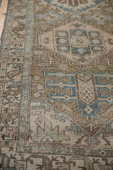 Distressed geometric birds and floral motifs with meandering vine border in olive and blue tones.