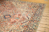Low, even pile of a vintage Heriz showing its brick red geometric field and intricate navy border.