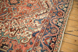 Corner view of a vintage Heriz carpet's unusual navy blue border with a meandering dragon-style vine.