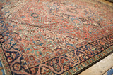 Angled view showing the Heriz carpet's geometric field and unusual dragon style vine border.