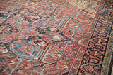 Dense hand-knotted texture of a vintage Persian Heriz with brick red and navy blue palmettes.