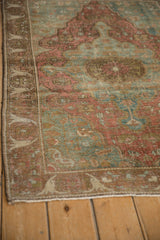 Antique Distressed Farahan Sarouk rug shows faded raspberry field, bell-shaped floral border.