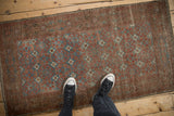 Distressed Belouch runner showing worn geometric guls and foundation in dusty red, blue tones.