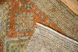 Textured, distressed terracotta and green pile, revealing the hand-knotted Heriz rug foundation.