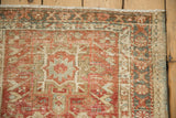 Geometric pattern and abrash of distressed Karaja runner corner in brick red, beige, and dusty teal.
