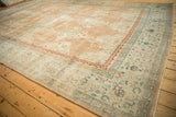 Distressed Kashan rug border featuring meandering vines and scrolled floral blossoms.