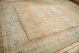 Distressed vintage Kashan carpet featuring beige border with blue vine motifs and red floral band.