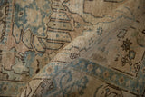 A folded view of the distressed Tabriz rug reveals its character-rich low pile and visible knot heads.