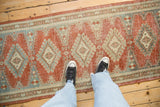Textured vintage Veece runner with abrasions revealing dusty ruby red and slate blue design.