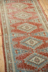 Distressed pile of vintage Veece runner, diamond patterns in ruby, silver, and blue.