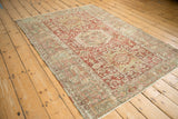 Full angled view of the distressed Karaja rug's geometric pattern and time-softened brick red tones.
