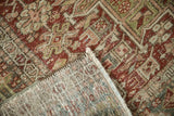Folded corner of a vintage Karaja rug revealing its hand-knotted back and worn, low pile.