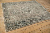 Angled close-up of the distressed vintage Karaja rug's geometric charcoal border and intact selvage.