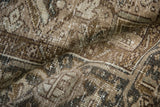 Close-up of the distressed rug's texture, showing mostly even wear and its low, hand-knotted pile.