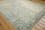 Corner perspective of a vintage Mehrivan rug's geometric border in powder blue, ivory, and pale coffee brown.