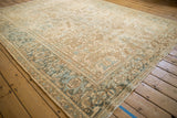 Corner view of a distressed Mehrivan carpet's Turtle Samovar border in soft slate blue and brown.