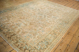 Angled view of a distressed Mehrivan carpet showing its geometric floral field and Turtle Samovar border.