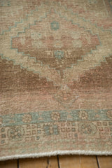 Distressed texture of a vintage Serab runner with muted blush, beige, and turquoise geometric motifs.