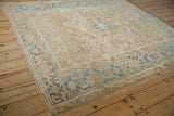 Vintage distressed Heriz rug corner, highlighting secure selvage and soft blue border patterns.