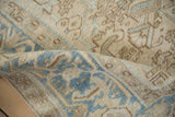 Even wear across knot heads on distressed Heriz rug in beige and dusty blue.