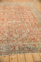 Angled view showing the low-pile texture and geometric leaf design of a distressed Heriz carpet.
