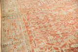 Angled close-up of a distressed Heriz showing the Samovar Turtle border and worn ruby red pile.