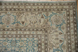 Evenly worn corner of a vintage Tabriz rug displaying the intricate Herati floral border motif.