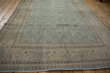 Low angle view of the distressed pile and Herati border on a vintage Tabriz carpet.