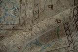 Rolled view of a distressed Tabriz carpet showing its low pile and even wear.